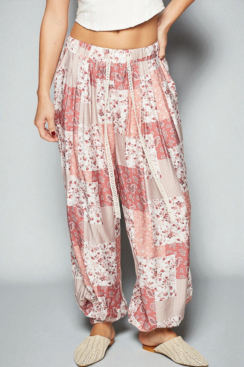 Floral patterned pants worn by a person on a plain background