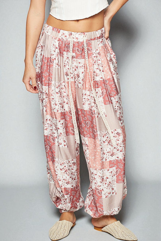 Floral patterned pants worn by a person on a plain background