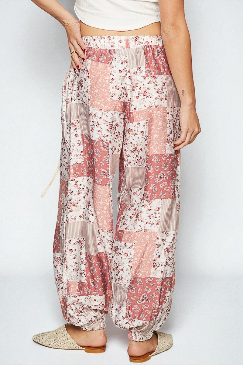Floral patterned pants worn by a person on a white background