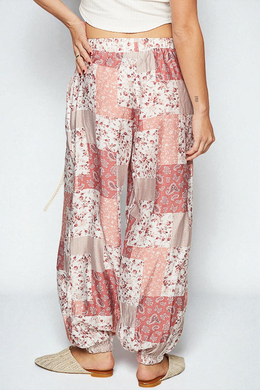 Floral patterned pants worn by a person on a white background