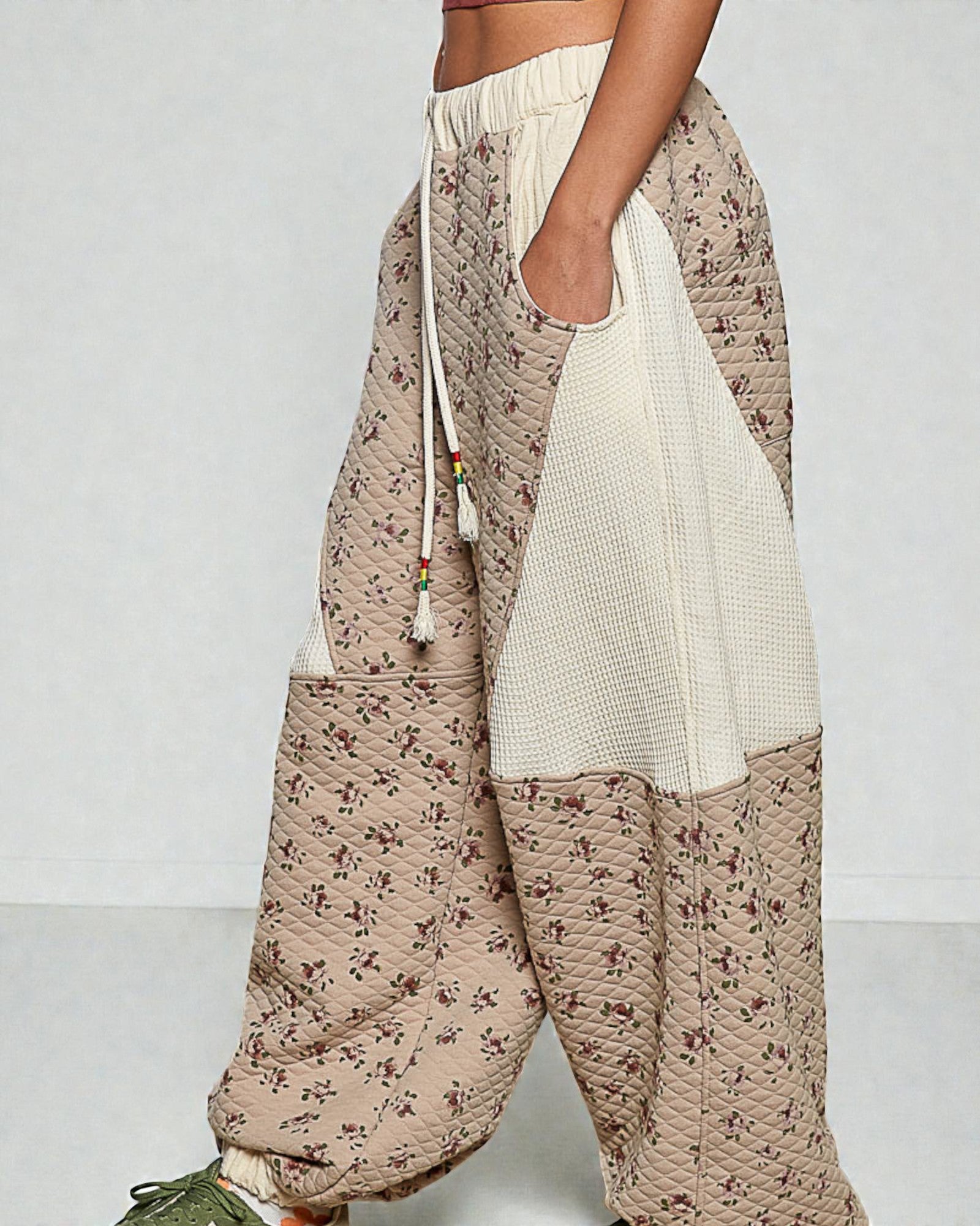 Floral-patterned pants with a white pocket on a plain background