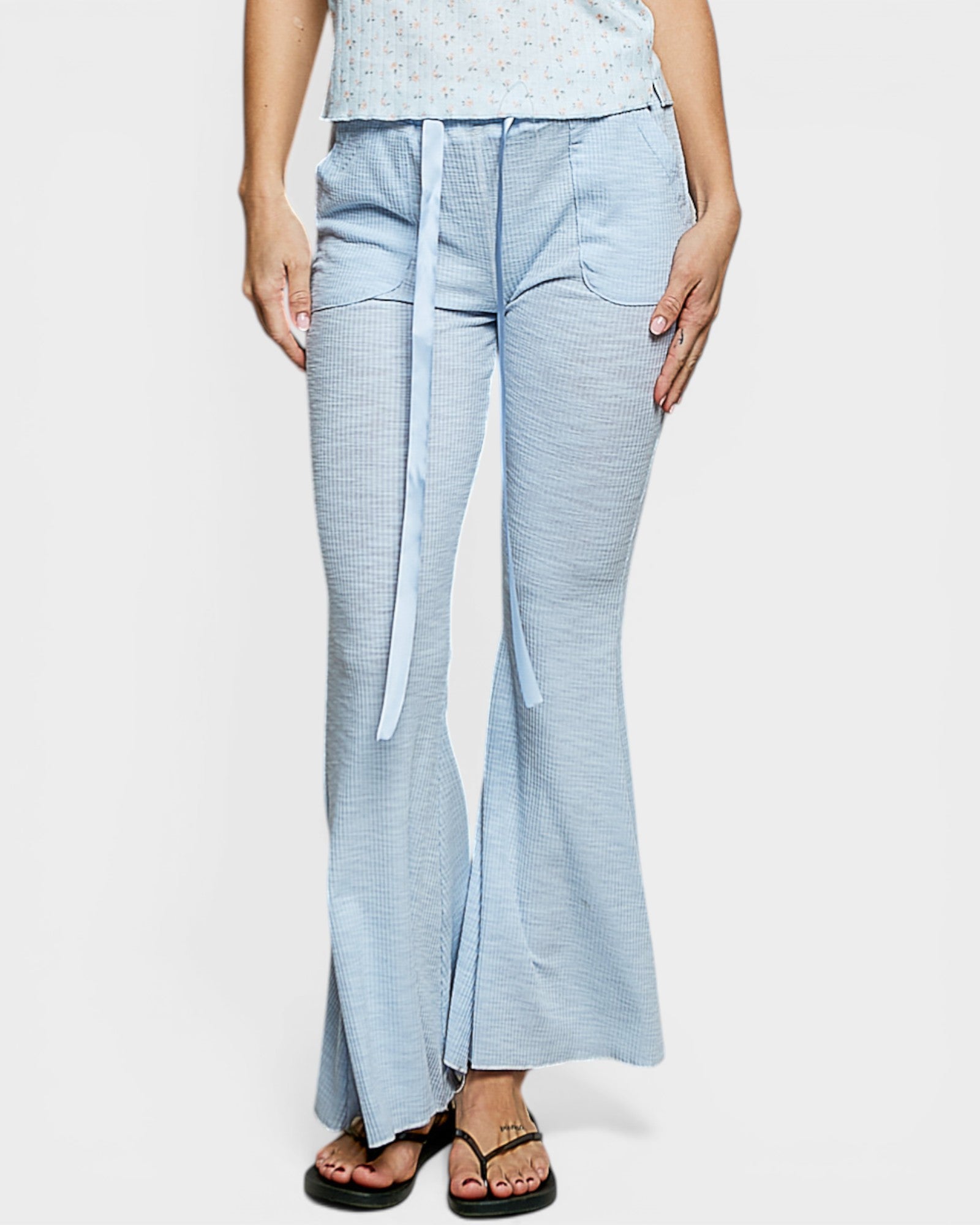 Light blue checkered pants with a belt worn by a person on a white background