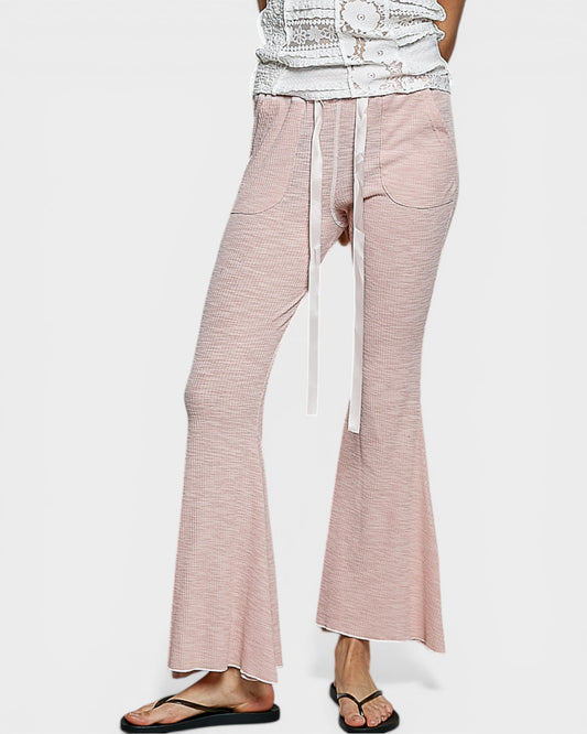 Pink flared pants with a white background