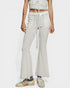 Person wearing light gray flared pants with a white background