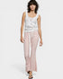 Woman wearing a sleeveless top and pink pants on a white background