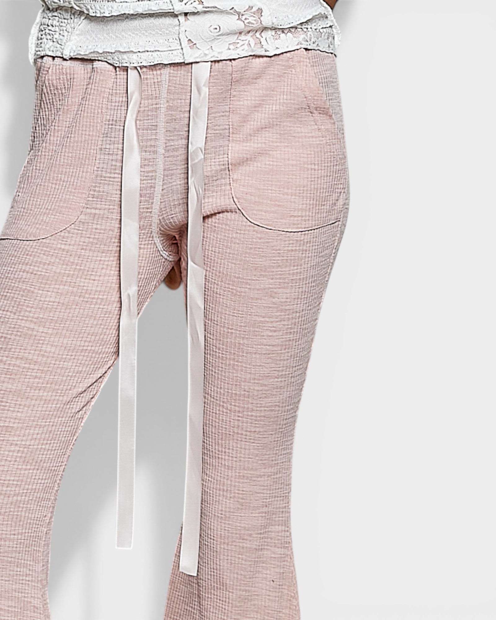 Pink checkered pants with a white belt on a light gray background