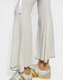 Person wearing light-colored pants and sneakers on a white background