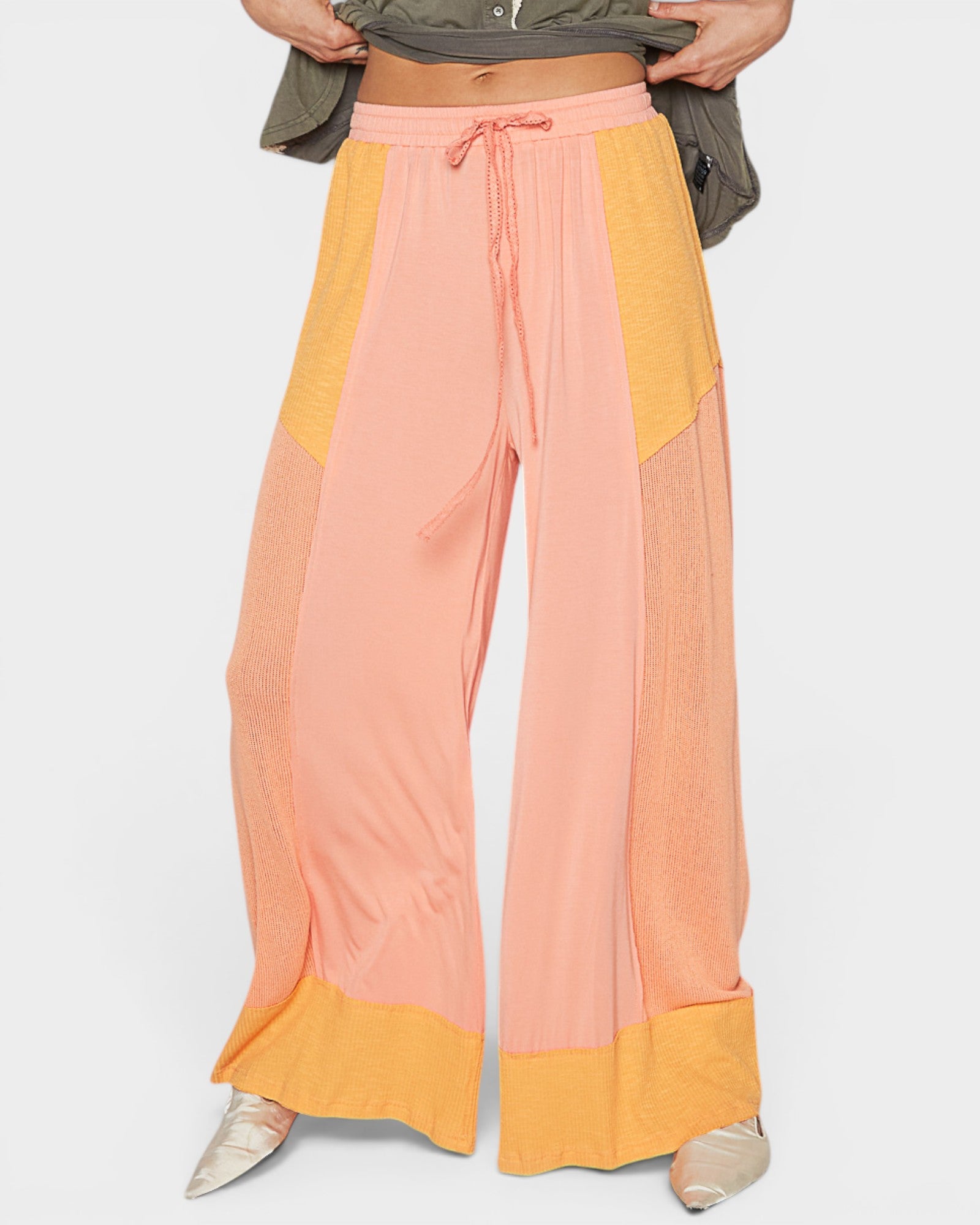 Color-blocked pants with pink and yellow sections on a white background
