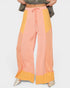 Color-blocked pants with pink and yellow sections on a white background