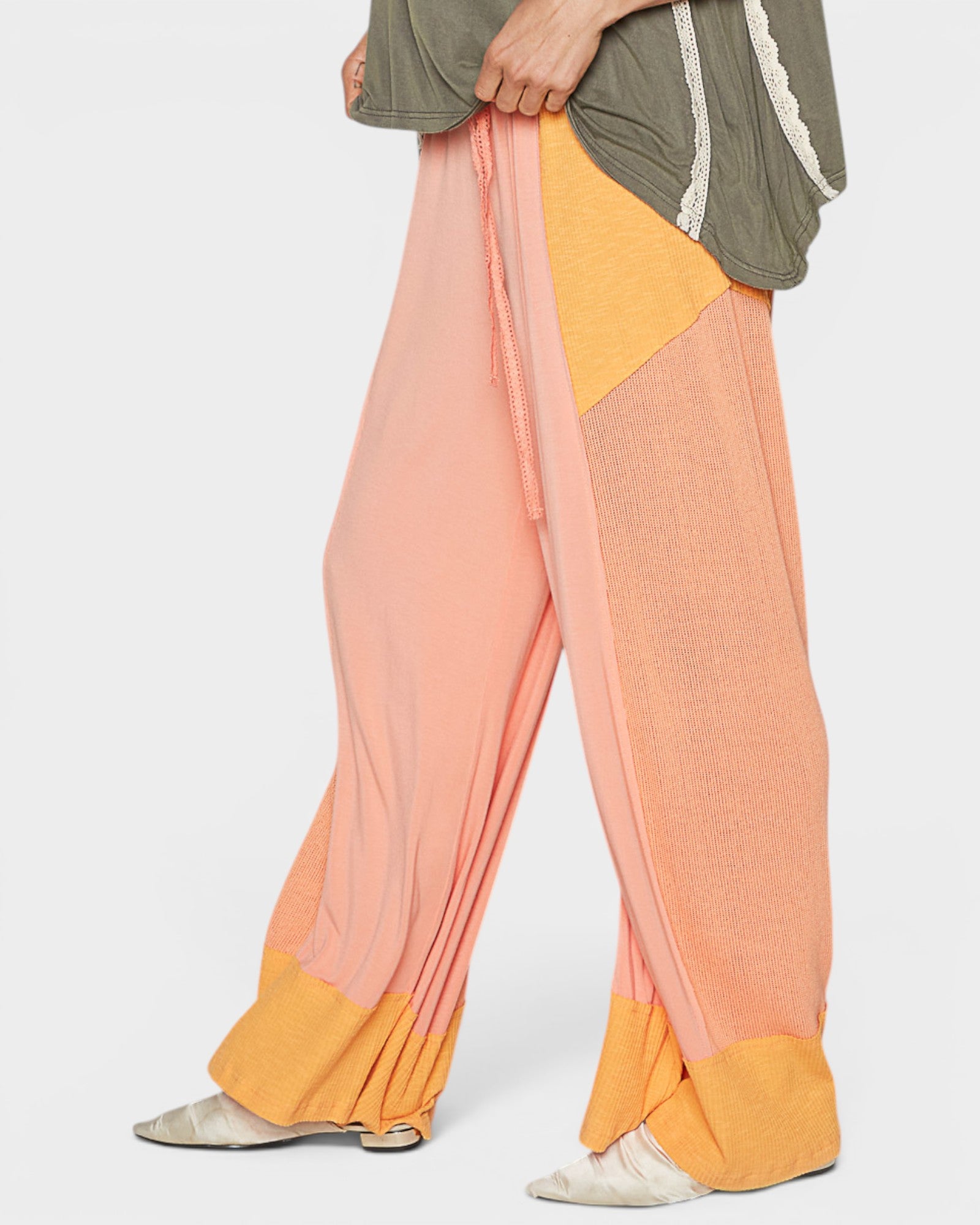 Color-blocked pants with orange, pink, and yellow sections on a white background