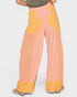 Color-blocked pants with pink and yellow sections on a white background