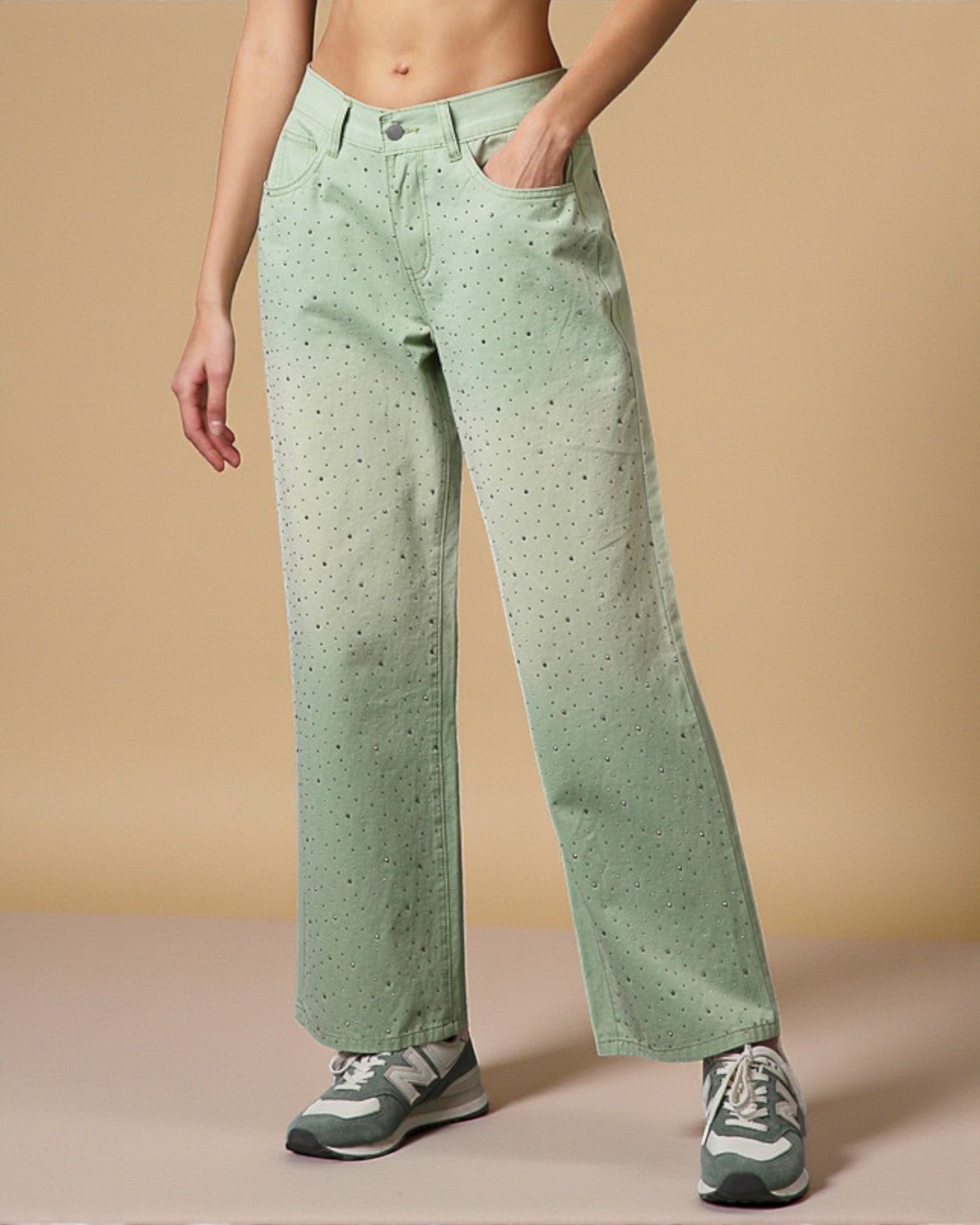 Person wearing light green patterned pants on a beige background