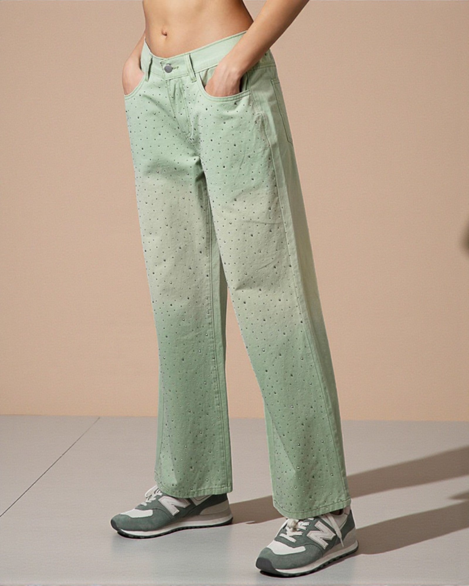 Person wearing light green pants with a subtle pattern on a beige background