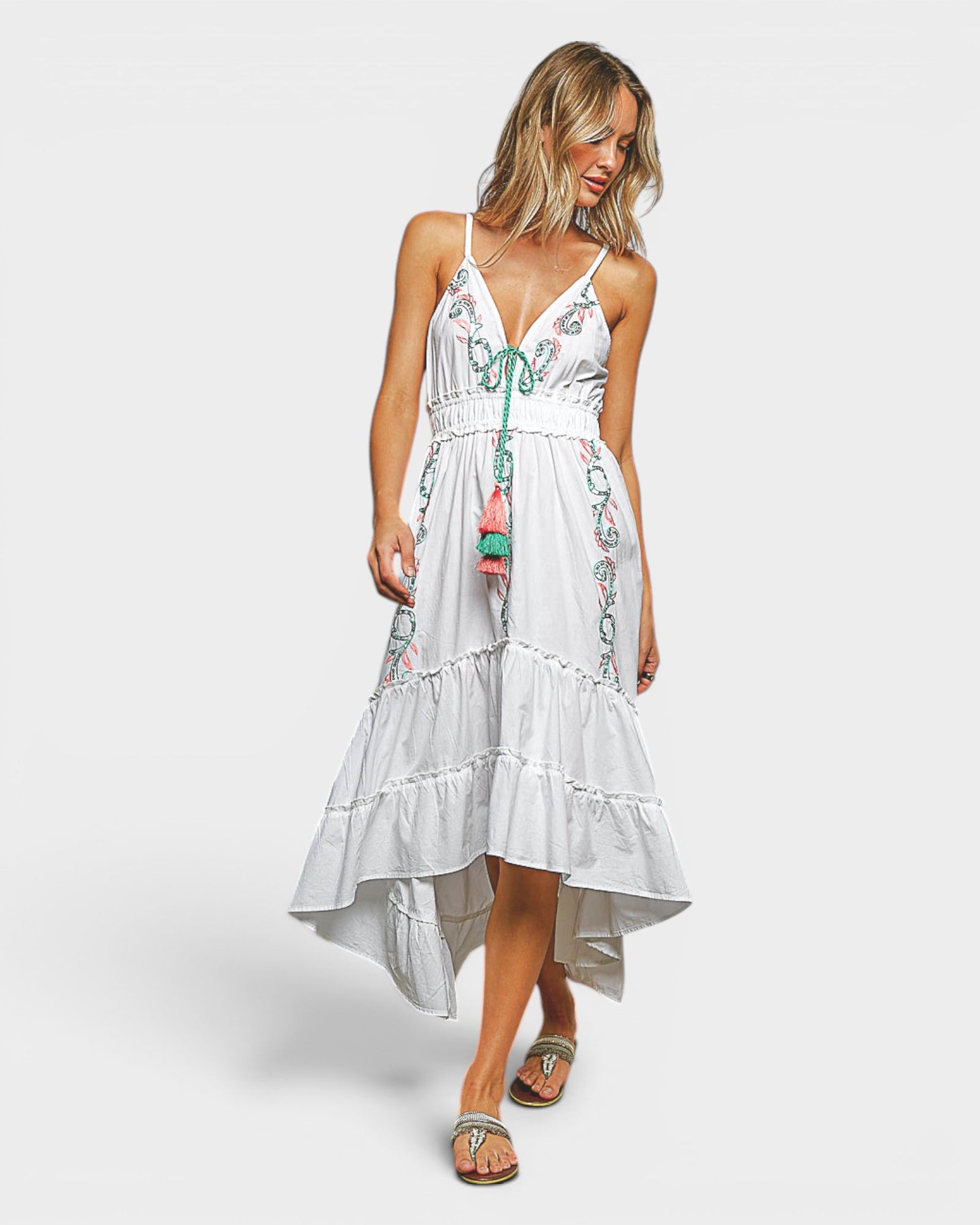 Woman wearing a white floral dress on a plain background