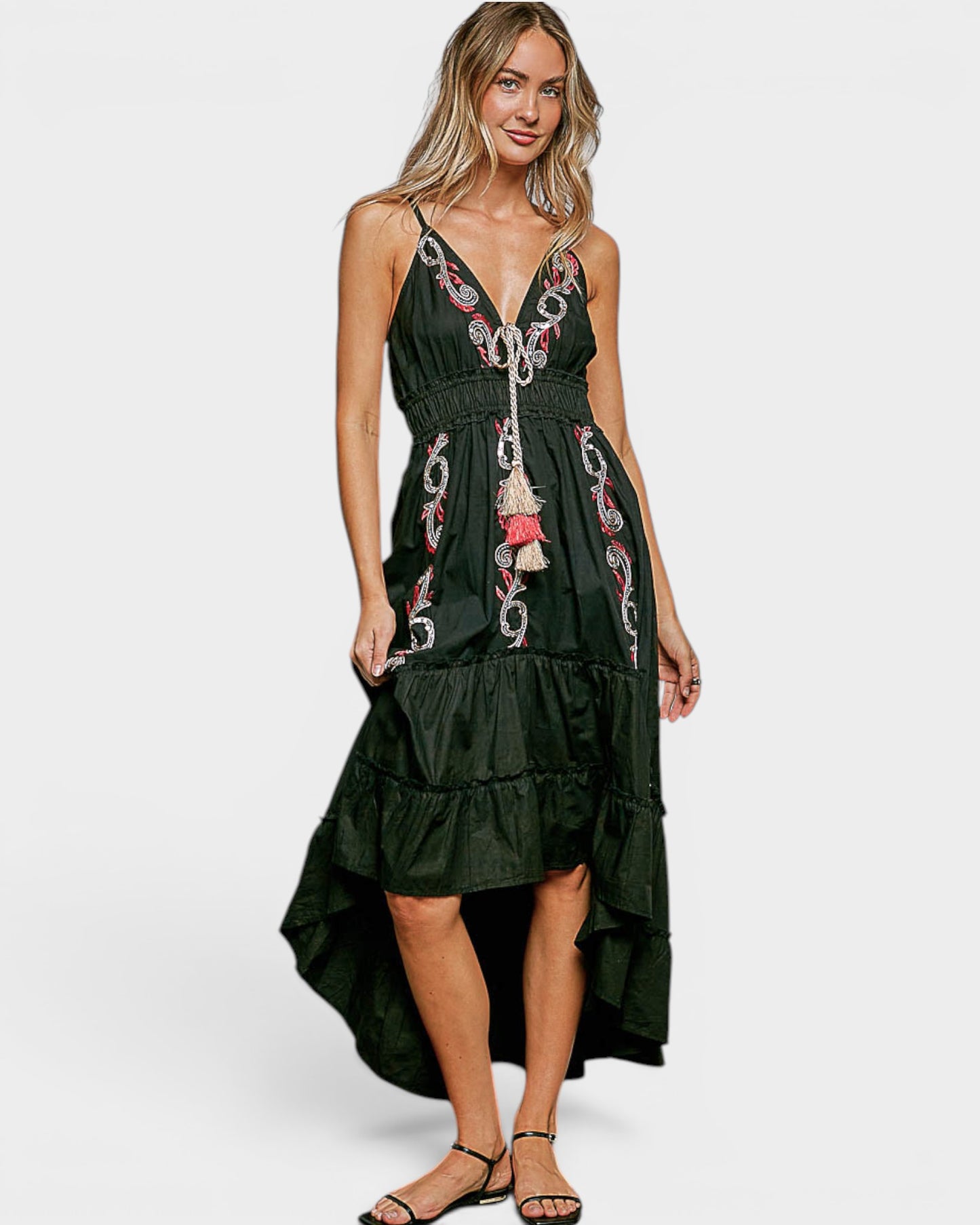 Woman wearing a black dress with floral embroidery on a white background