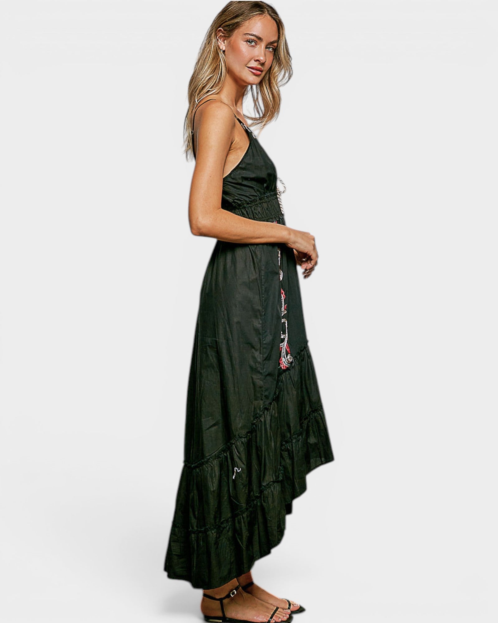 Woman wearing a black dress with floral details on a white background