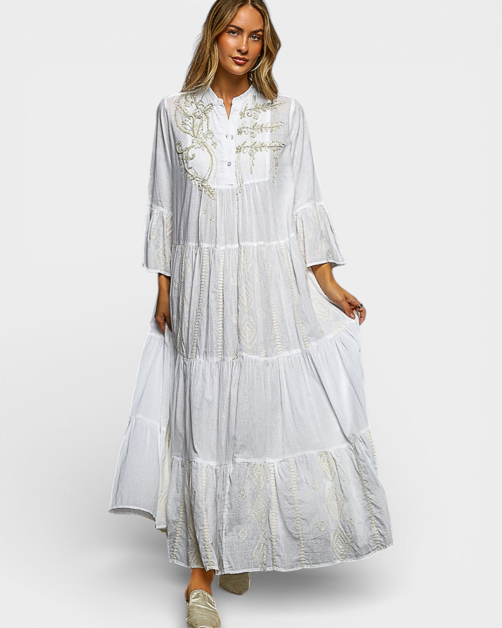 Woman wearing a white dress with embroidery on a white background