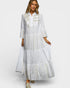 Woman wearing a white dress with embroidery on a white background