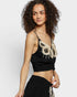 Woman wearing a black top with lace details on a white background