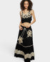 Woman wearing a black outfit with floral lace details on a white background