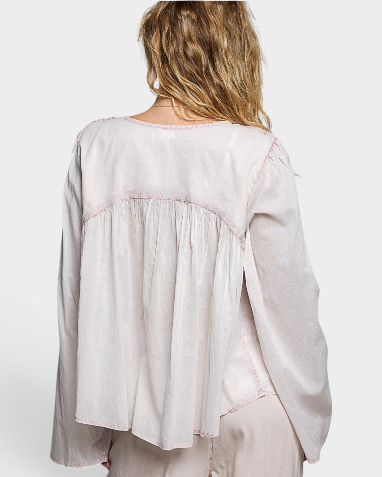 Light pink blouse worn by a person on a white background