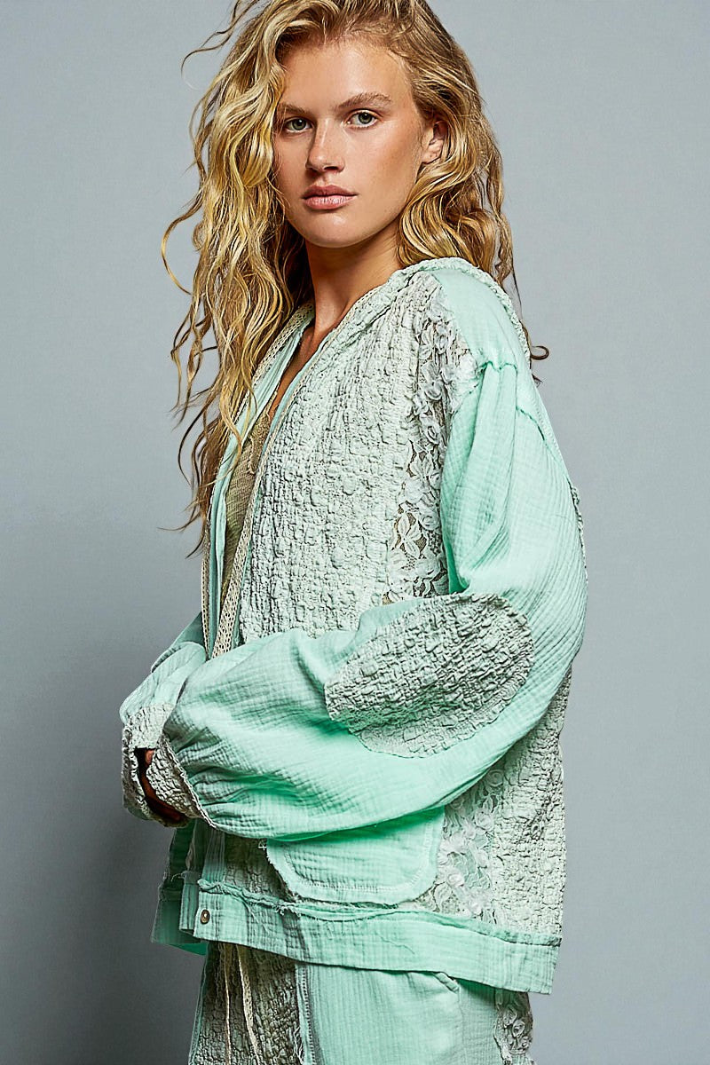 Woman wearing a light green textured outfit against a gray background