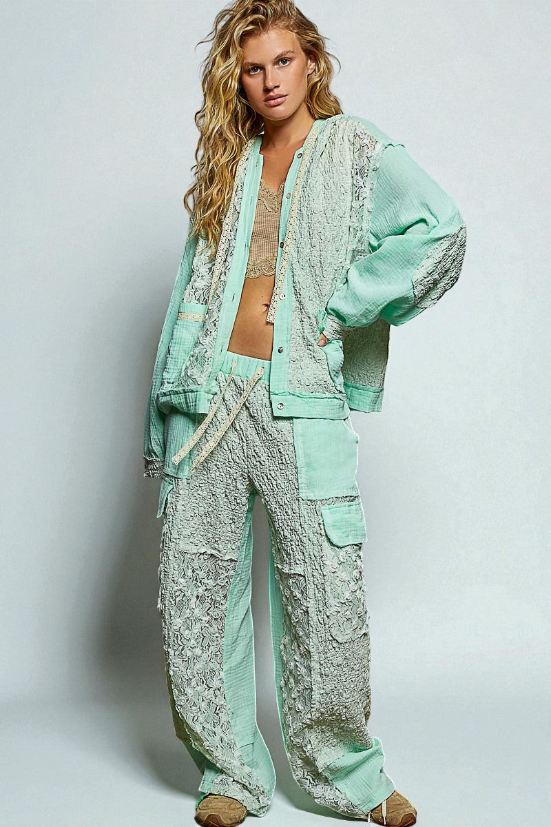 Woman wearing a light green lace outfit on a plain background