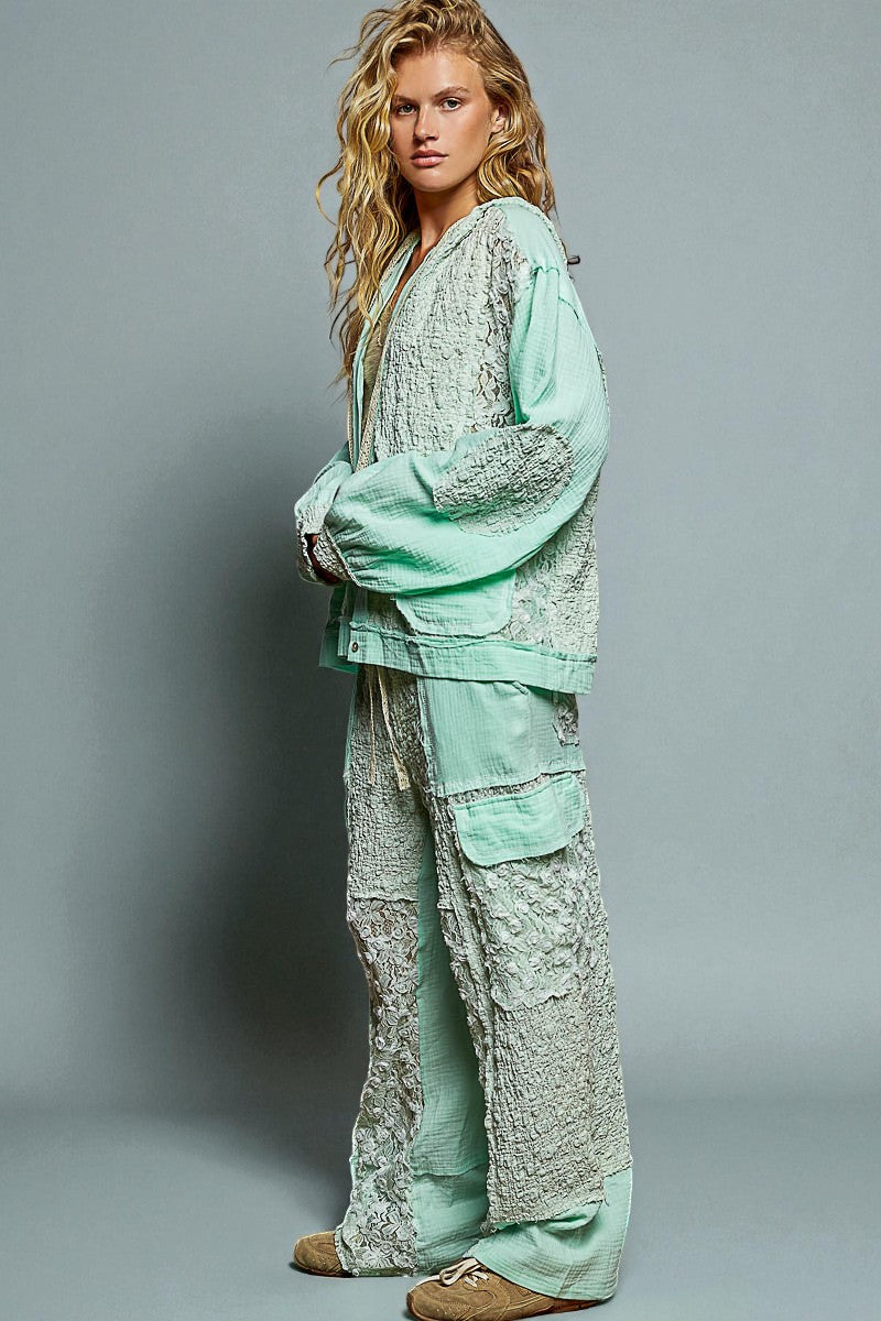 Woman wearing a light green textured outfit against a gray background