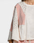Light-colored top with floral and striped patterns on a plain background