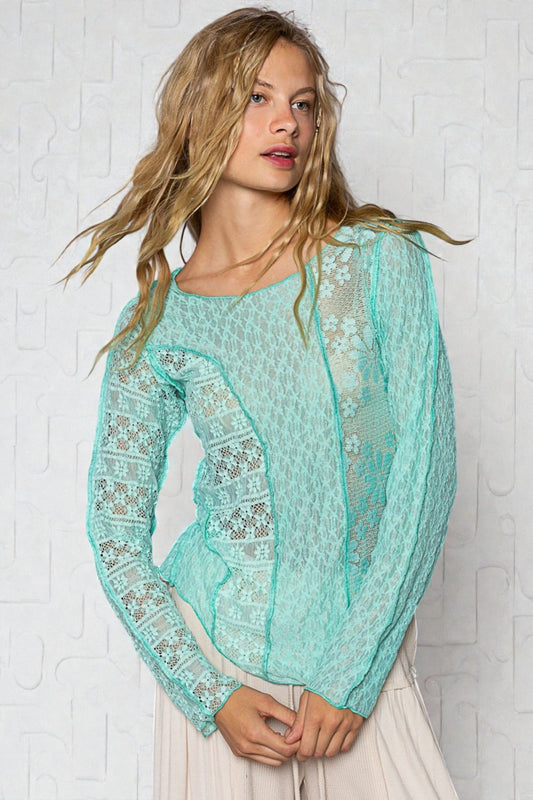 Woman wearing a light blue lace top against a white background