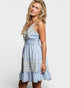 Woman wearing a light blue dress with lace details on a white background