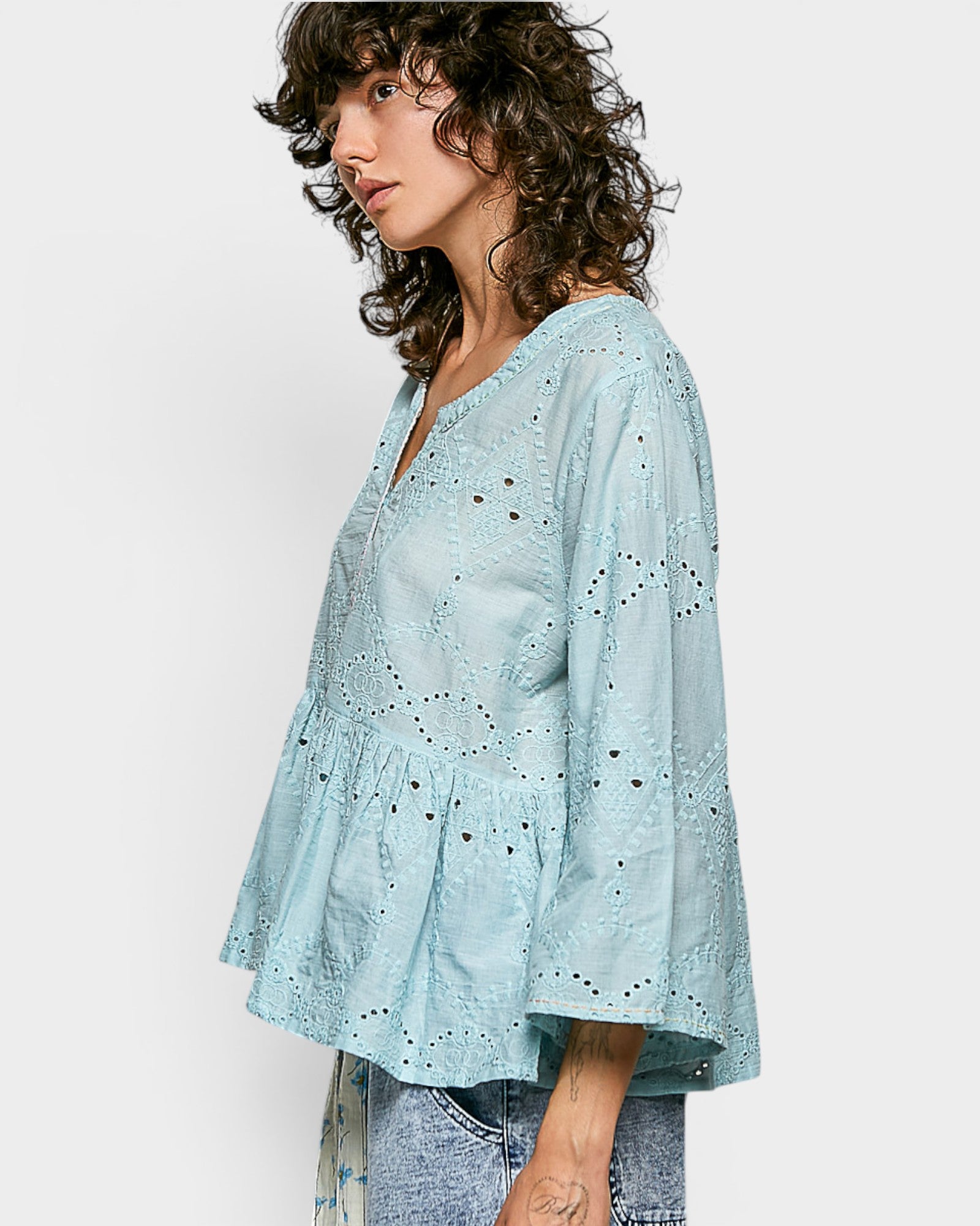 Woman wearing a light blue blouse with a white background