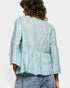 Light blue embroidered blouse worn by a person on a white background