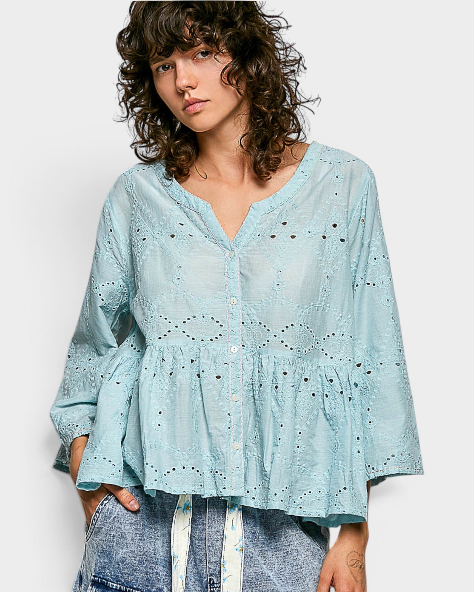 Woman wearing a light blue blouse with a white background