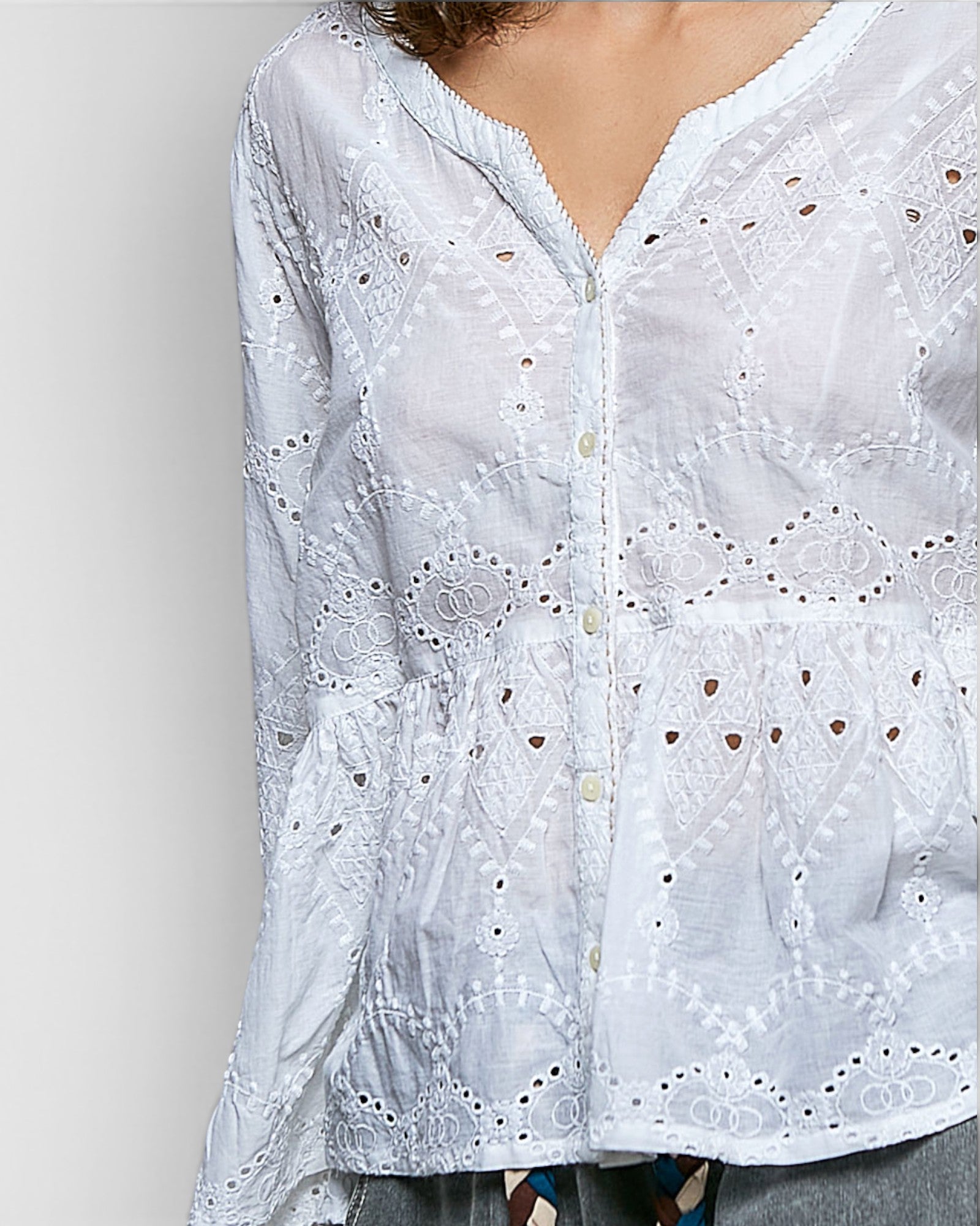 White embroidered blouse on a plain background