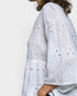 White embroidered blouse with long sleeves on a white background