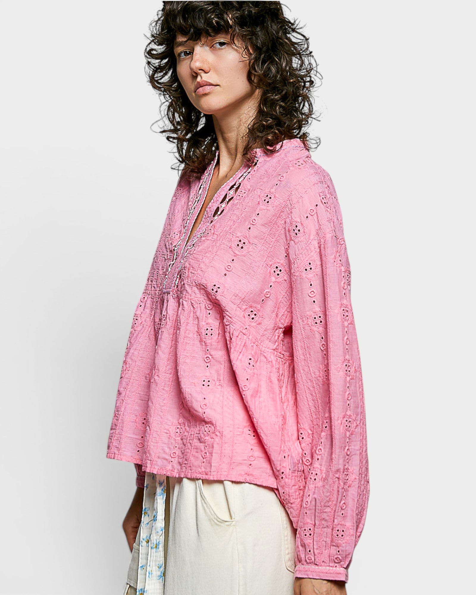 Woman wearing a pink blouse with a white background