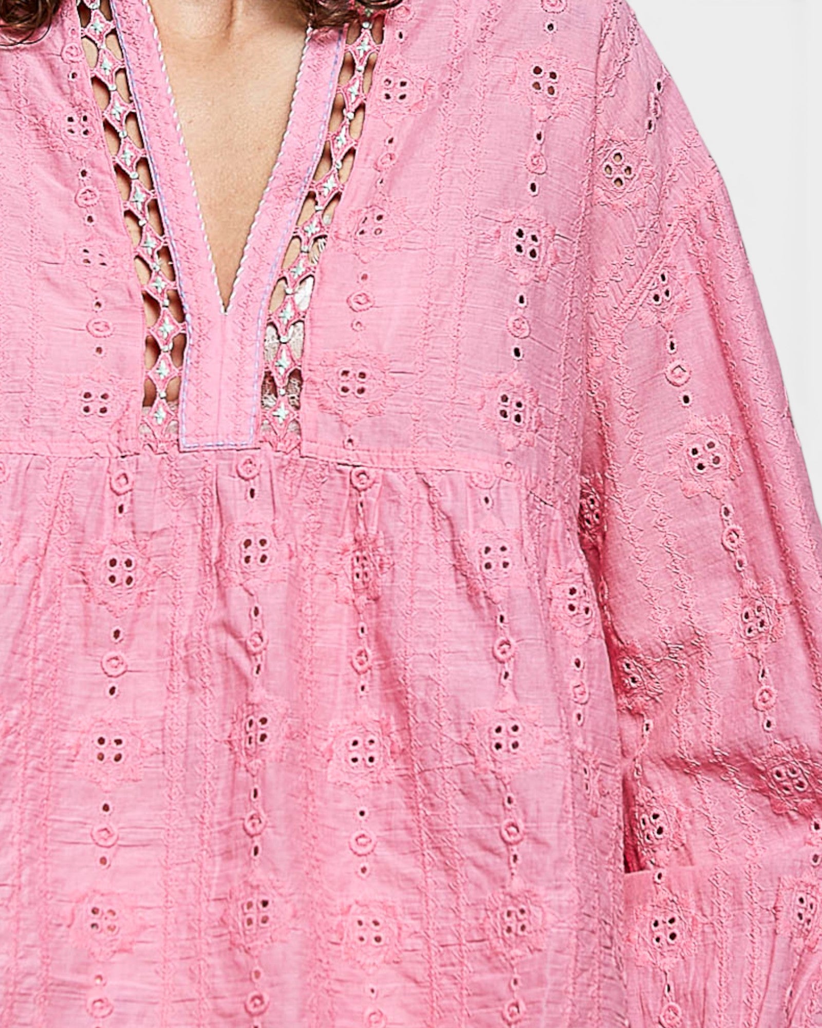 Close-up of a pink embroidered dress with intricate patterns.