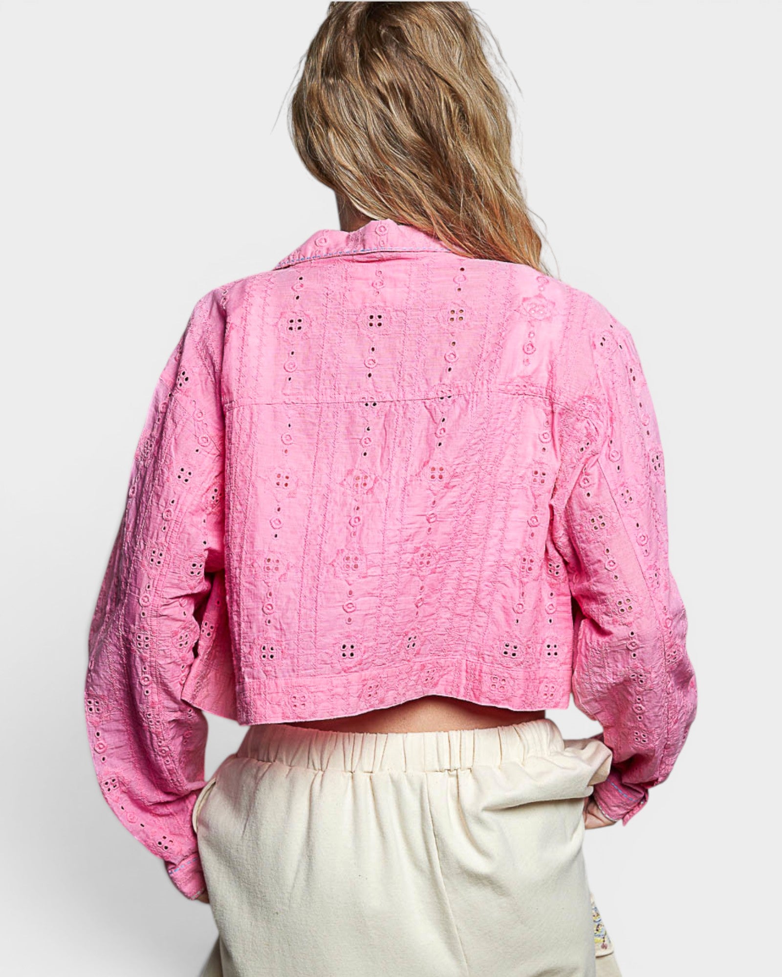 Person wearing a pink floral jacket on a white background