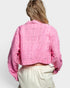 Person wearing a pink floral jacket on a white background