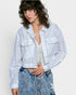 Person wearing an off white embroidered jacket and denim pants on a white background