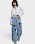 Person wearing an off white embroidered jacket and denim pants on a white background