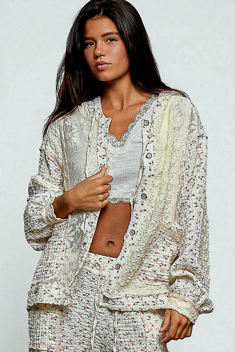 Woman wearing a light, patterned outfit against a plain background