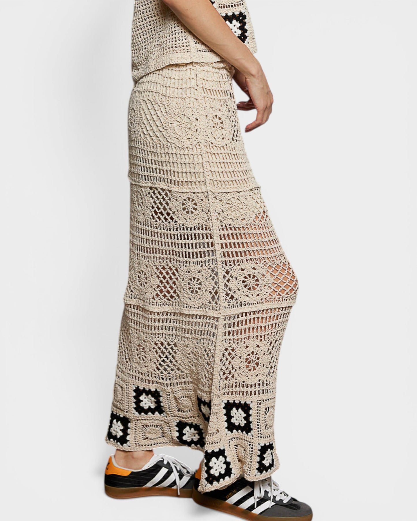 Beige crochet pants worn by a person on a white background