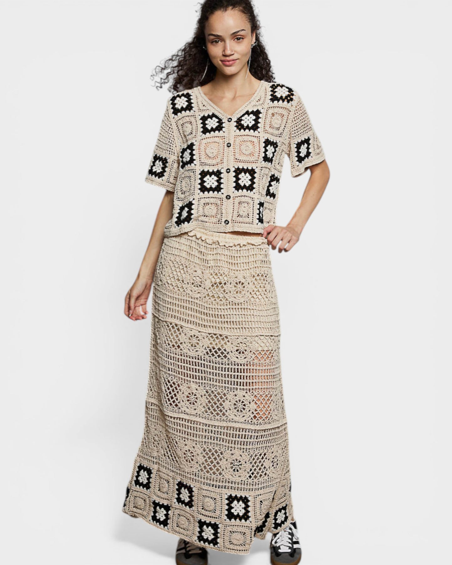 Woman wearing a crochet outfit with a top and long skirt on a white background