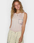 Woman wearing a light pink sleeveless top with a floral pocket design on a white background