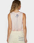 Woman wearing a sleeveless top with a decorative back design on a white background
