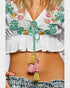 White embroidered top with colorful tassels and ruffles on a plain background