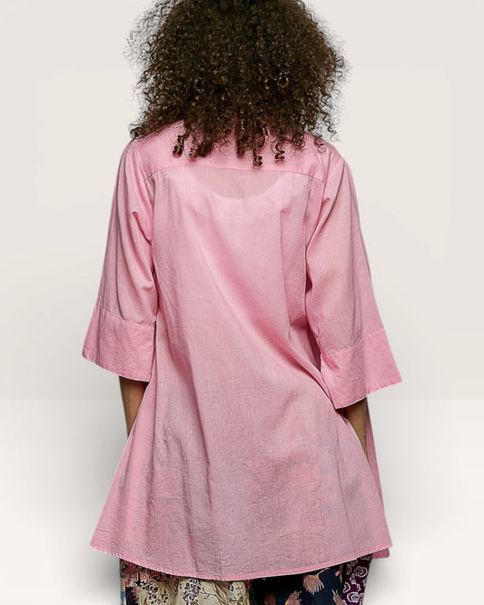 Person wearing a pink jacket on a plain background