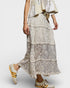 Person wearing a layered lace dress with Adidas sneakers on a white background